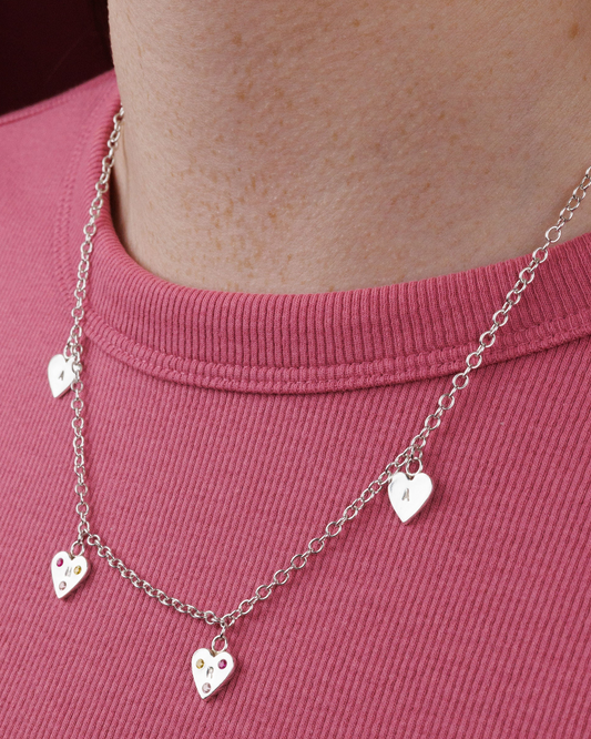 Necklace with heart-shaped pendants on a pink shirt