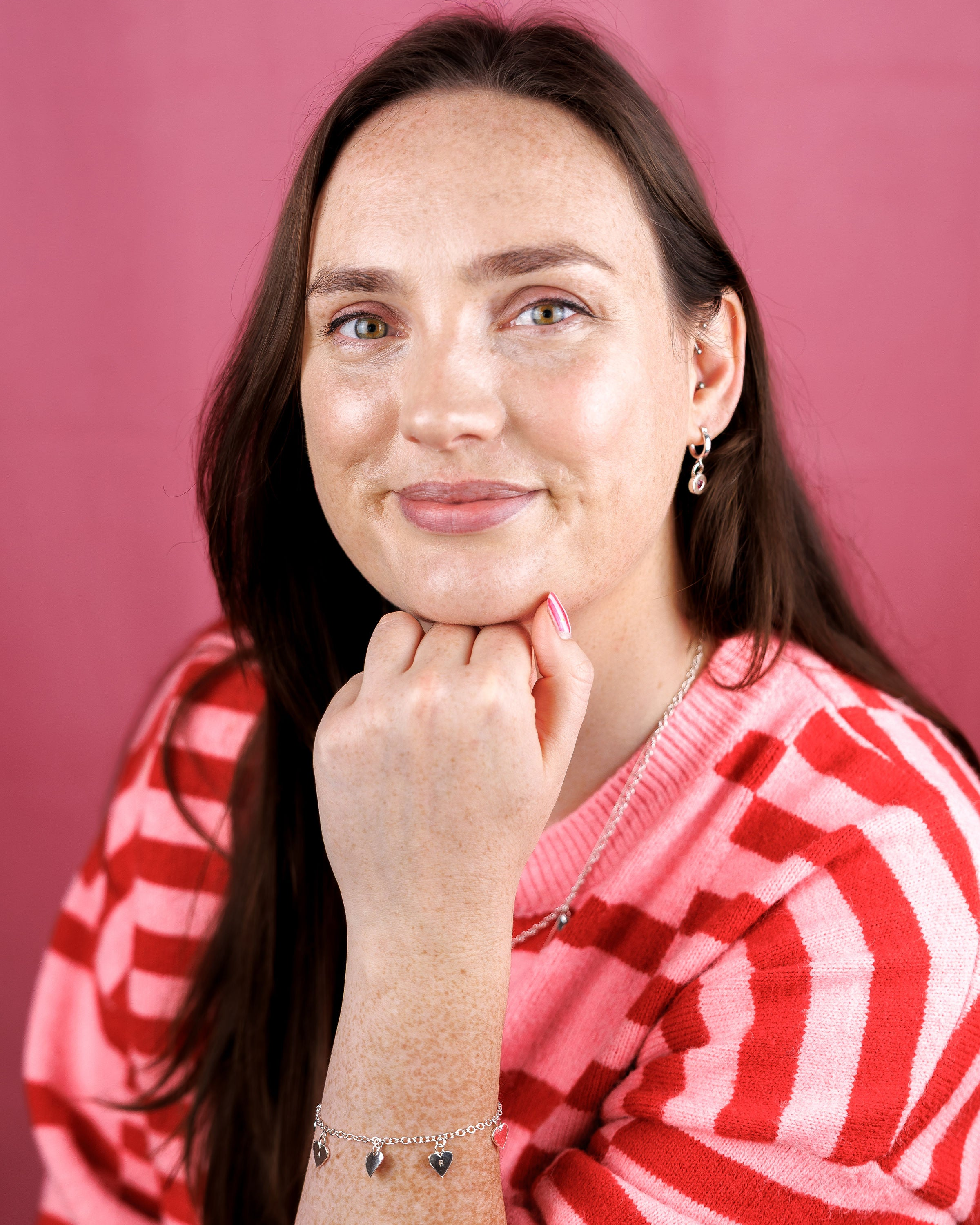 Woman wearing a red and white striped sweater against a pink background