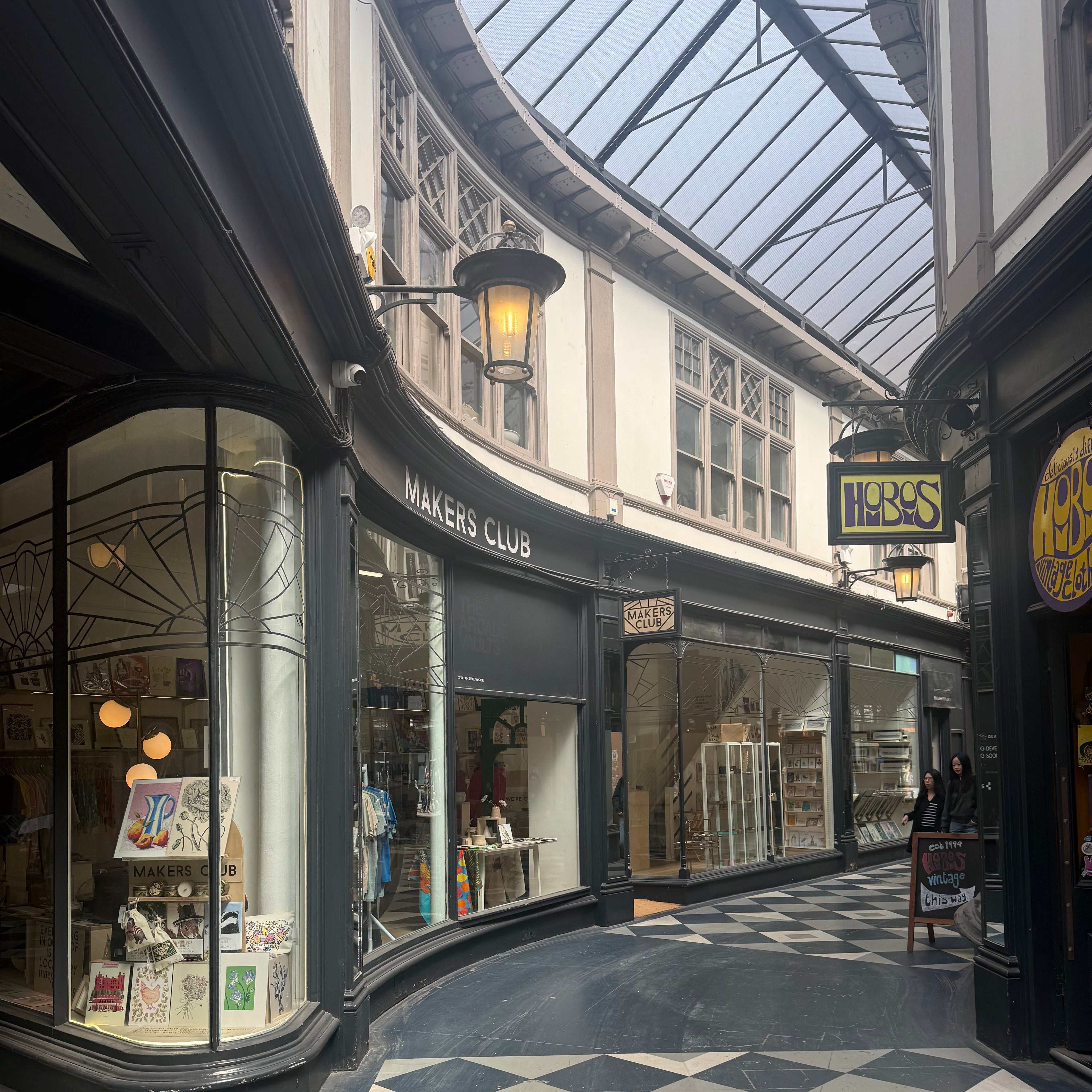 A checkered floor with a glass ceiling and reflections of buildings.